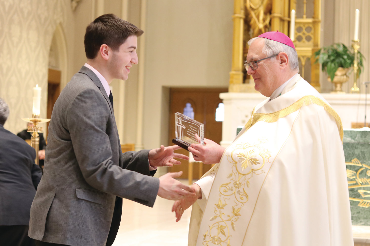 Nicholas Carpentier, of St. Agatha Church, Woonsocket, one of the 23 recipients of the 2019 St. Timothy Award, is congratulated by Bishop Tobin. The St. Timothy Award is a national honor given annually to outstanding juniors and seniors in high school or in their early college years who live as disciples of Christ by witnessing to their faith, demonstrating Gospel values through service to others and exhibiting Christian leadership.
